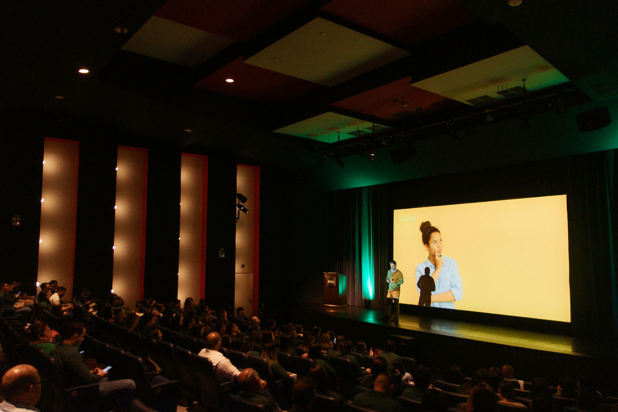 Allan Lorìa en auditorio con proyección en pantalla